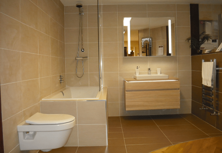 Designer bathroom with floating units and tiled walls and bath.